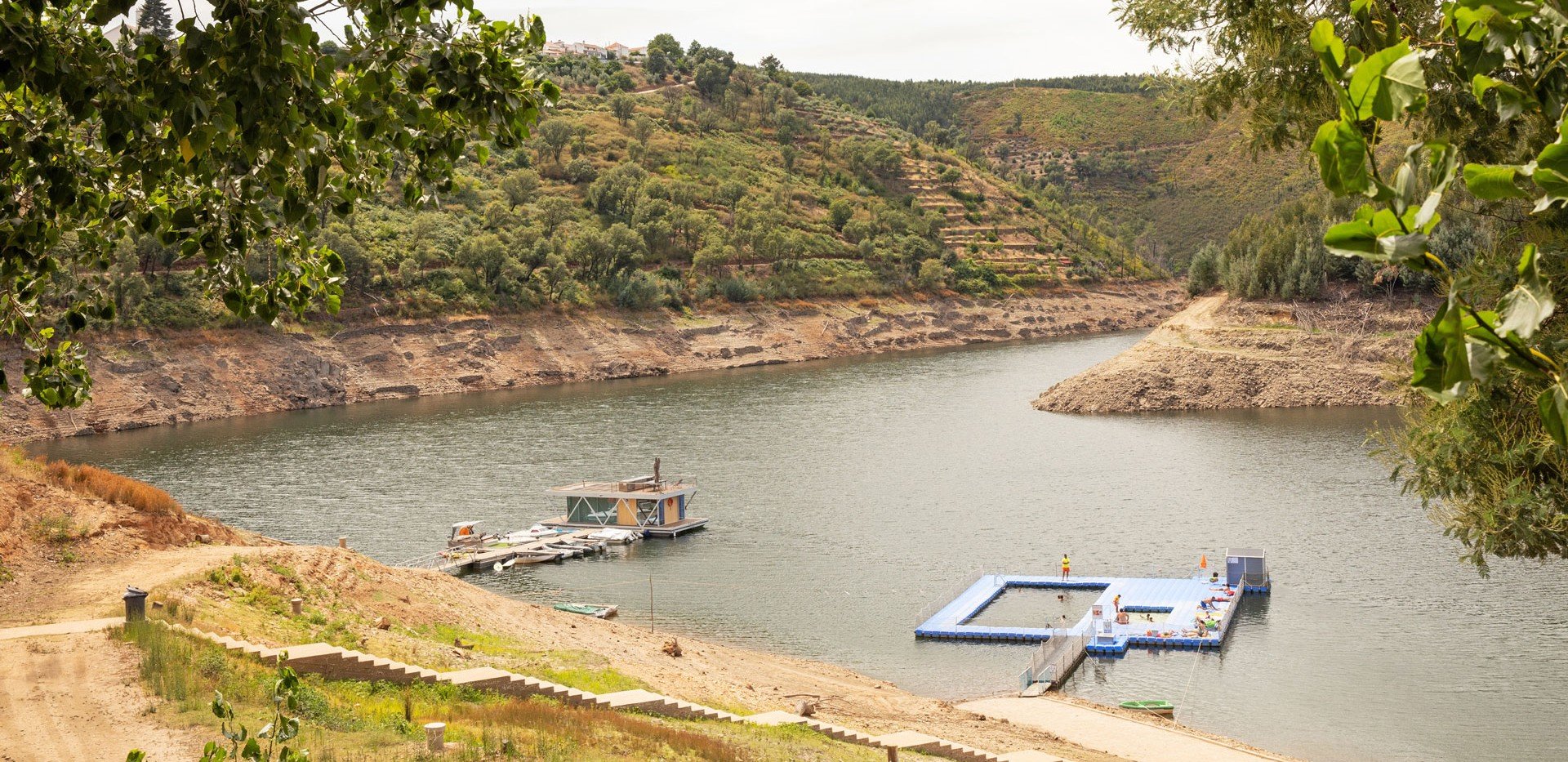 Praia Fluvial de Álvaro no rio Zêzere, com piscinas flutuantes entre as encostas