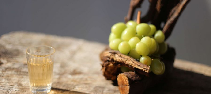 Copo de vinho Callum junto a uvas brancas e uma videira